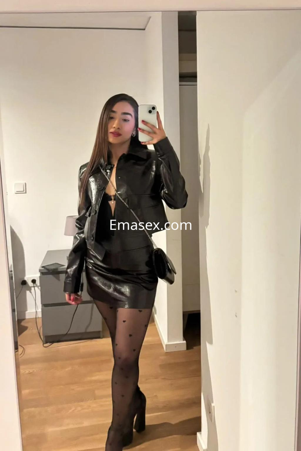 La puta se muestra posando en un espejo con un atuendo de cuero negro y medias con lunares en Valencia.