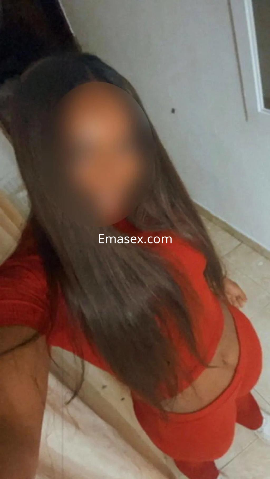 Puta con cabello largo y lacio, vestida con un conjunto rojo, posando en un interior en Alicante.
