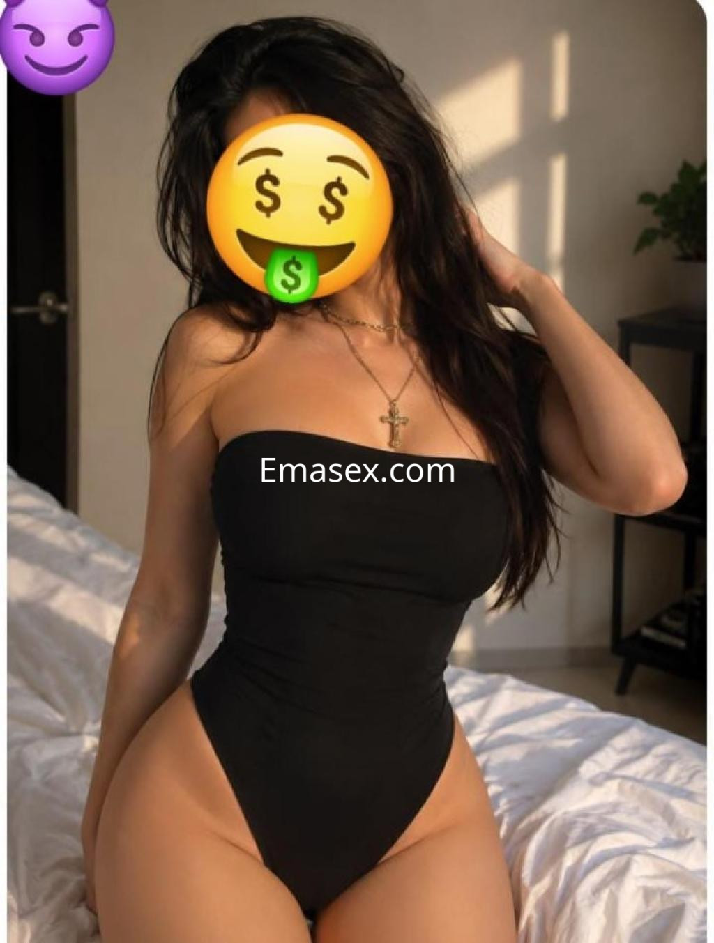 Escort en Burgos posando en lencería negra, con cabello largo y suelto, en un entorno de dormitorio.