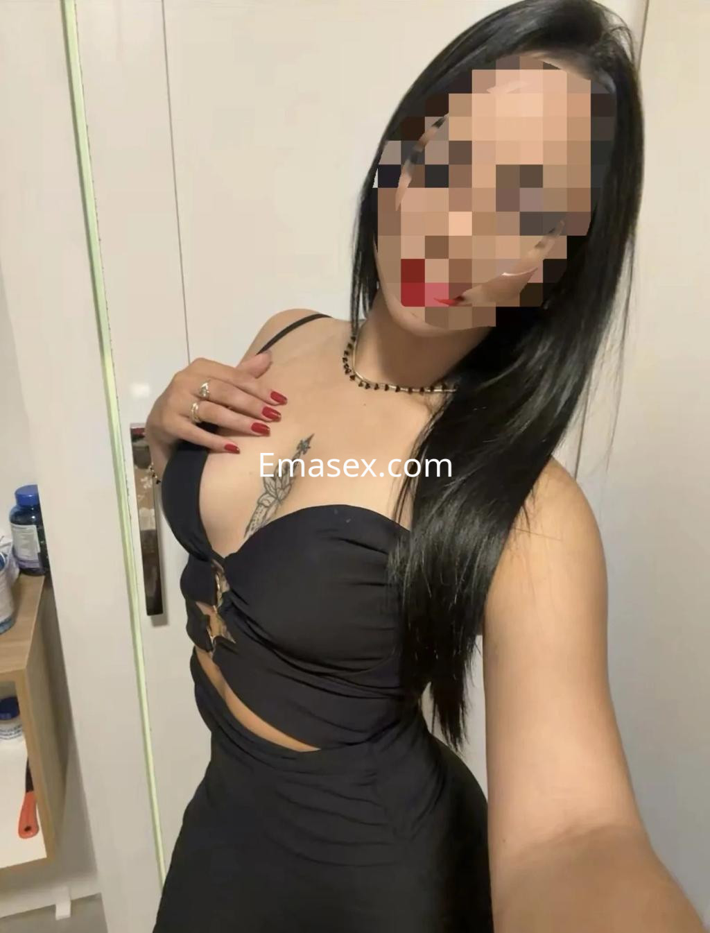 Escort en Madrid con cabello largo y lacio, vestida con un ajustado vestido negro y un collar elegante.
