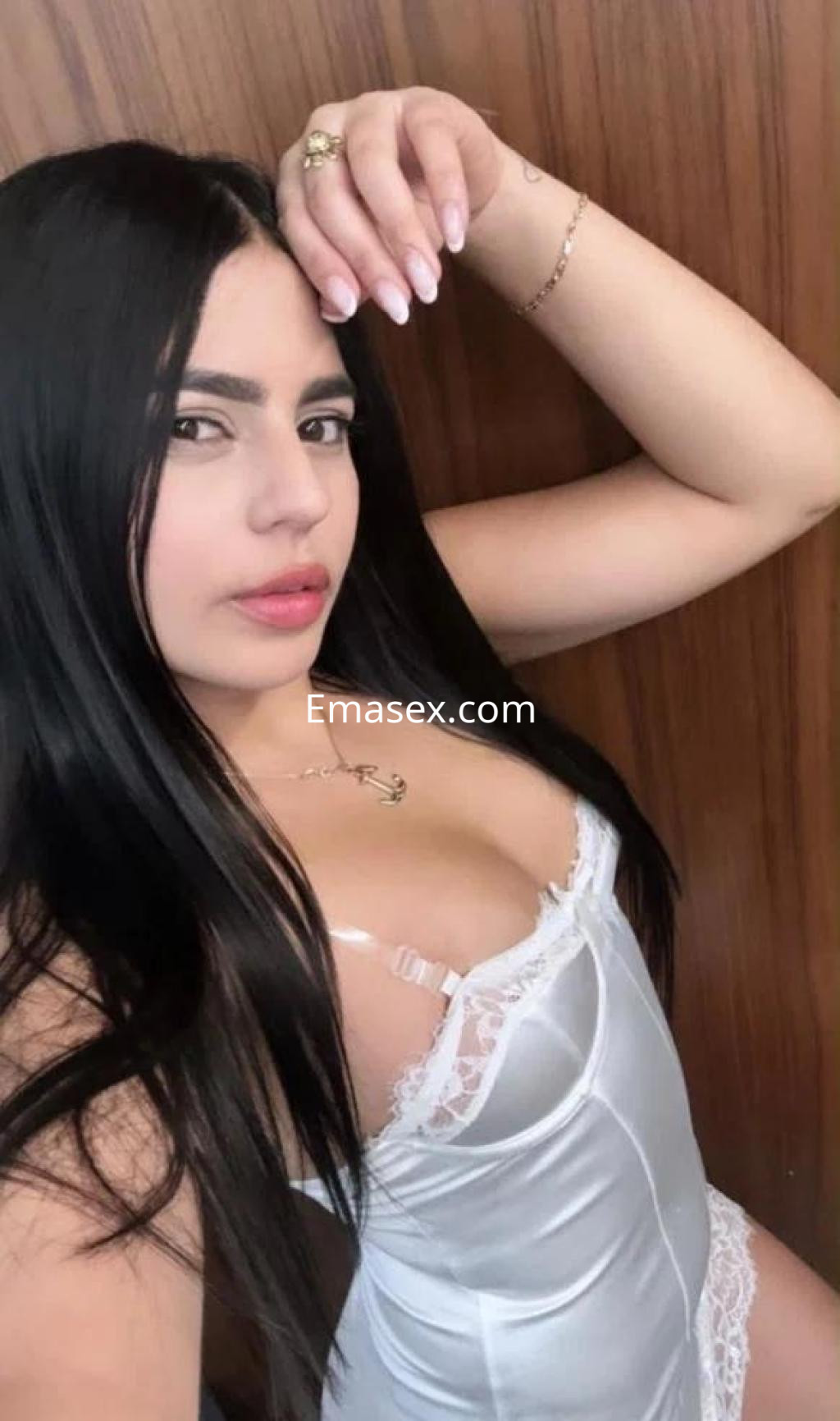 Escort en Málaga con cabello largo y lacio, vistiendo un conjunto de lencería blanca con detalles de encaje.