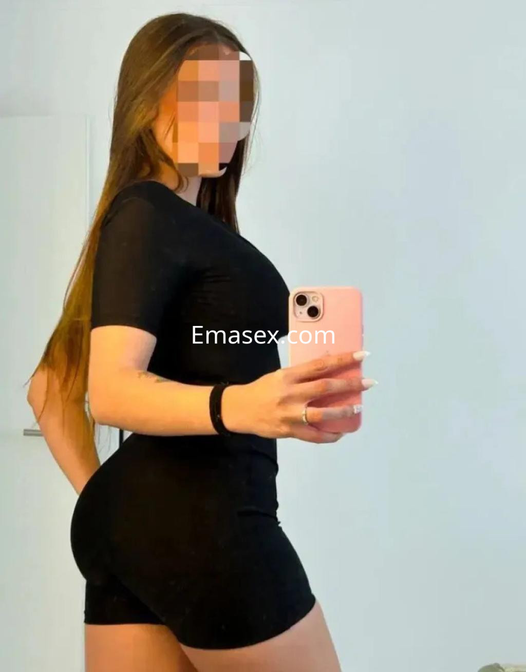 La puta luce un ajustado conjunto negro, posando de perfil en un ambiente bien iluminado en Murcia.