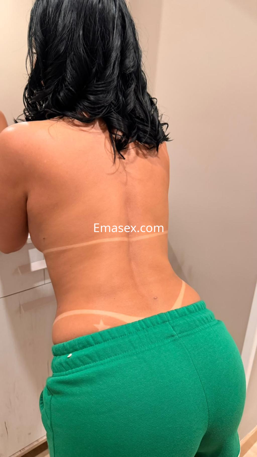 Puta de cabello oscuro y rizado, viste pantalones verdes ajustados y está de espaldas frente a un espejo en Vitoria.