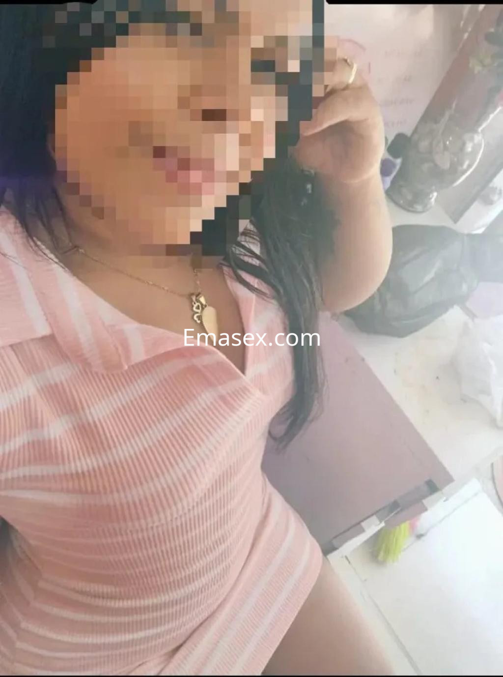 Escort en Córdoba con vestido de rayas claro, cabello largo y oscuro, posando con una sonrisa suave.