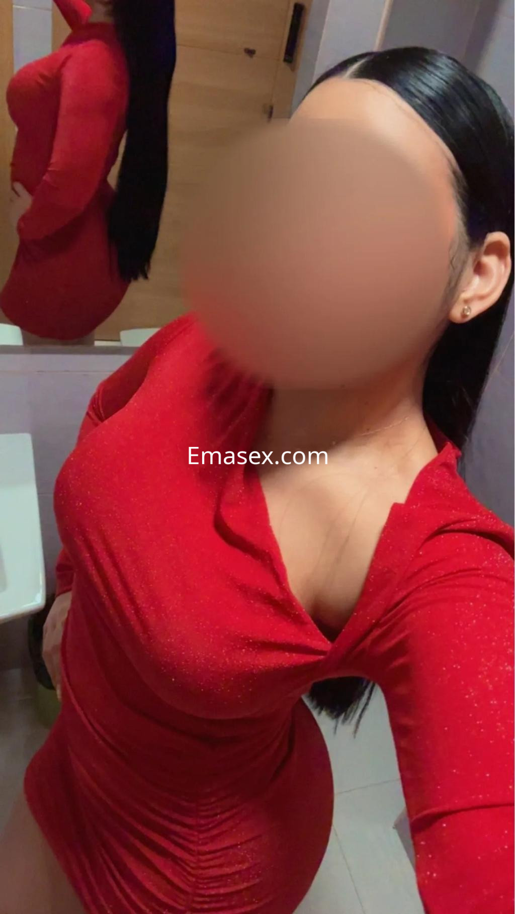 La puta en Vigo luce un vestido corto rojo brillante, con el cabello largo y lacio mientras se toma una selfie.