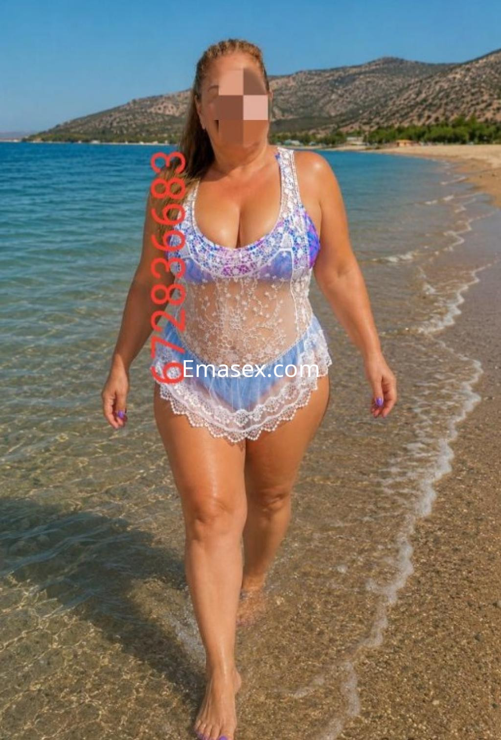 Puta camina por la orilla del mar en Oviedo, luciendo un vestido de baño transparente con detalles de encaje.