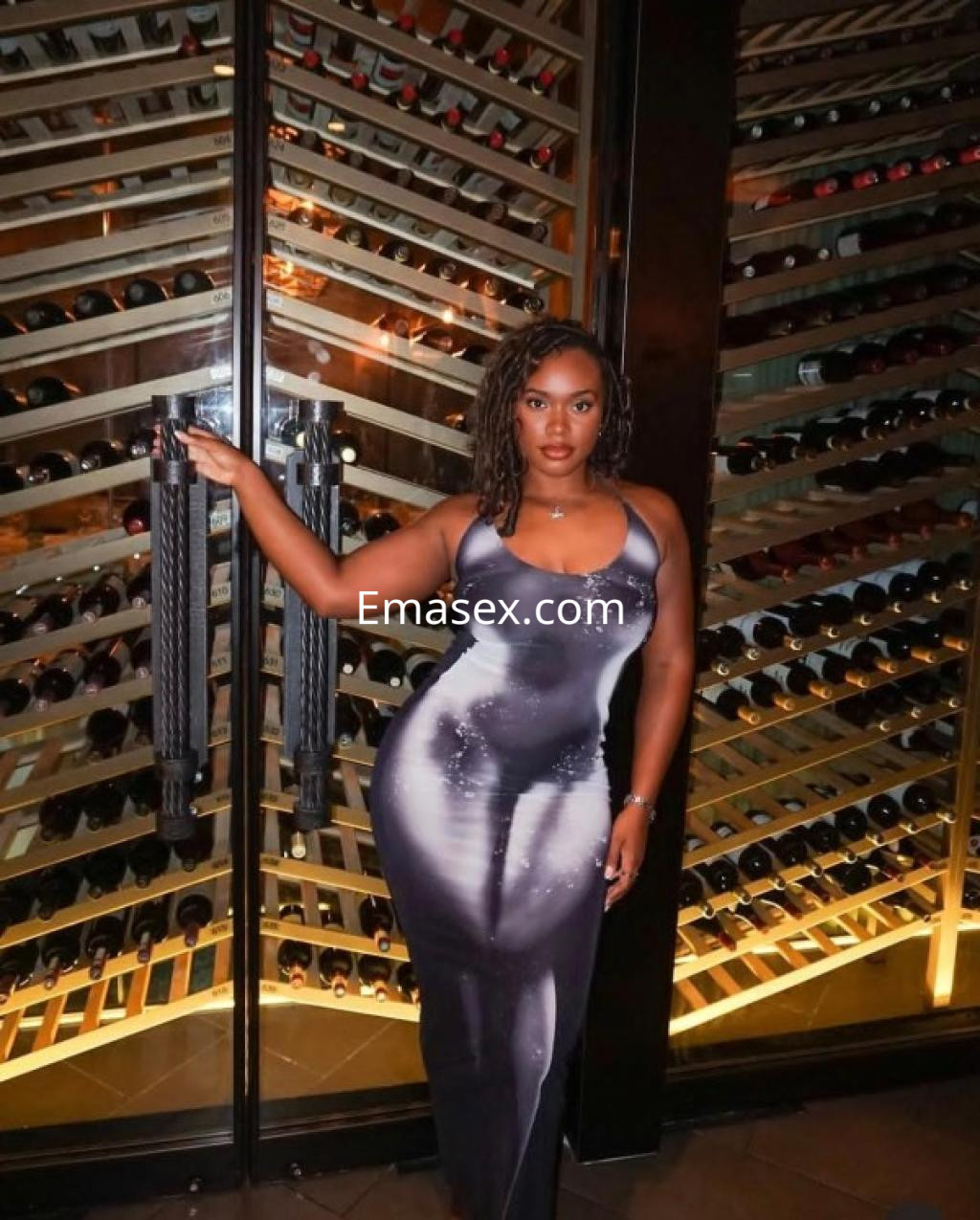 La puta en Tenerife luce un vestido ajustado y elegante, posando frente a una bodega de vinos.