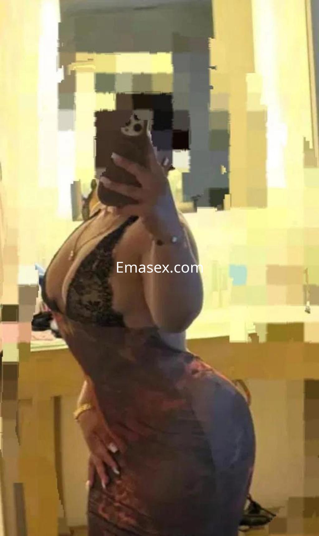 La puta en Badajoz luce un vestido ajustado y escote pronunciado, posando frente a un espejo.