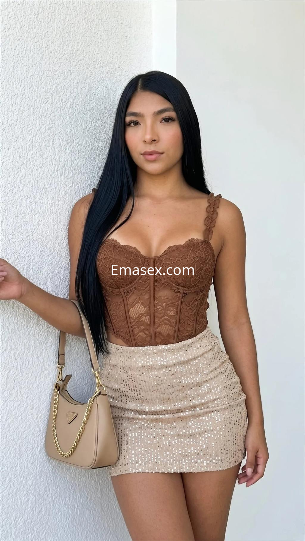 Escort en Murcia con cabello lacio y oscuro, viste un corset marrón y falda corta brillante, posando con una bolsa.