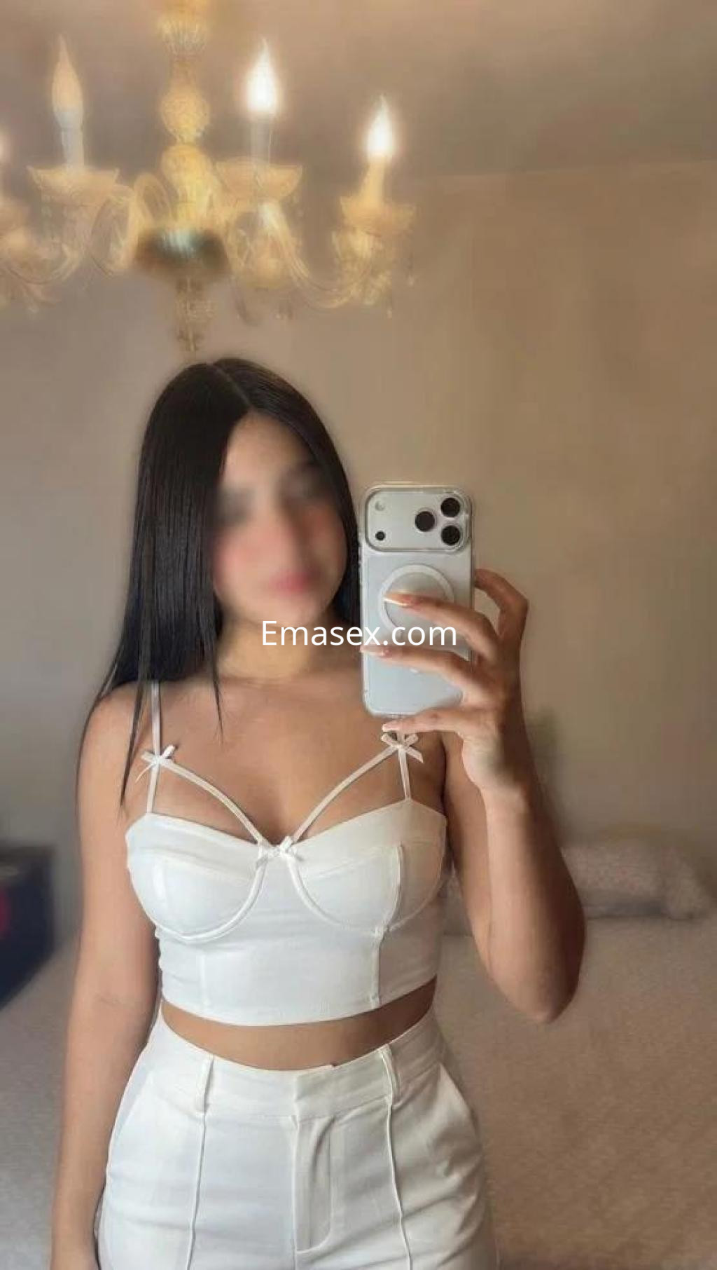 Escort en Oviedo con cabello largo y lacio, vistiendo un top blanco sin mangas y pantalones a juego.