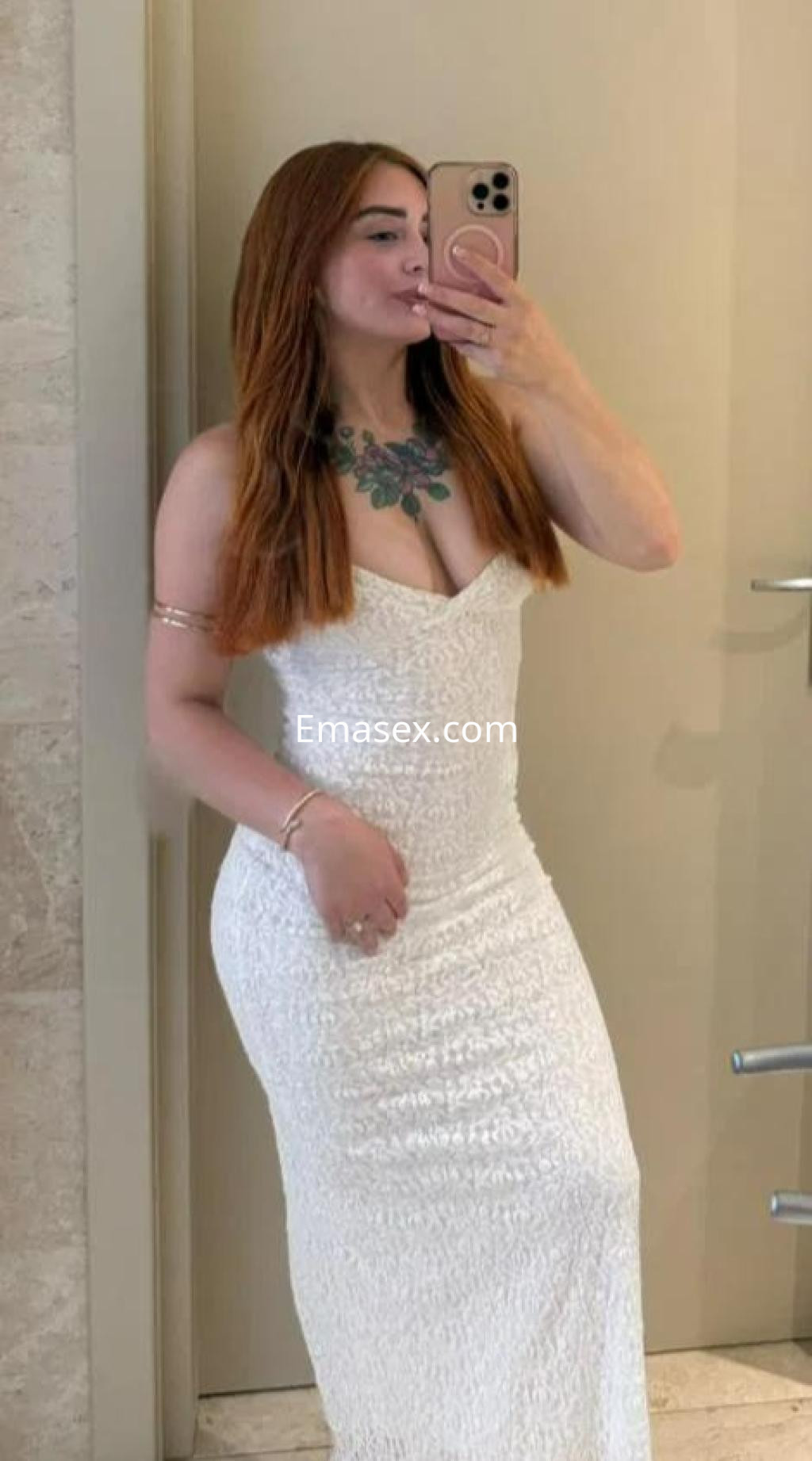 Puta con cabello largo y pelirrojo, viste un vestido blanco ajustado y luce un collar en Barcelona.