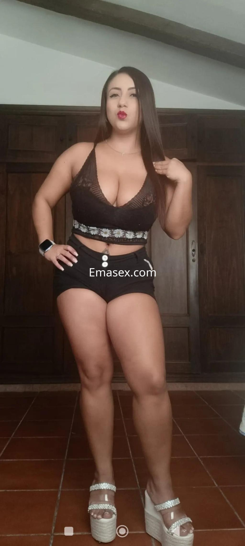 Escort en Burgos posando con top negro y shorts cortos, mostrando una actitud segura y elegante.