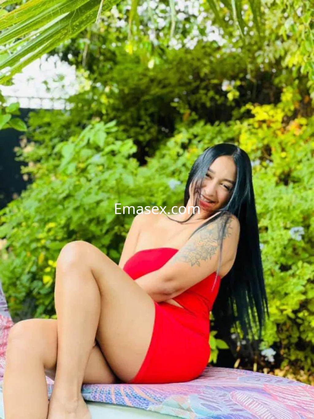 Puta posando con un vestido rojo en un entorno natural en Murcia, con cabello largo y lacio.
