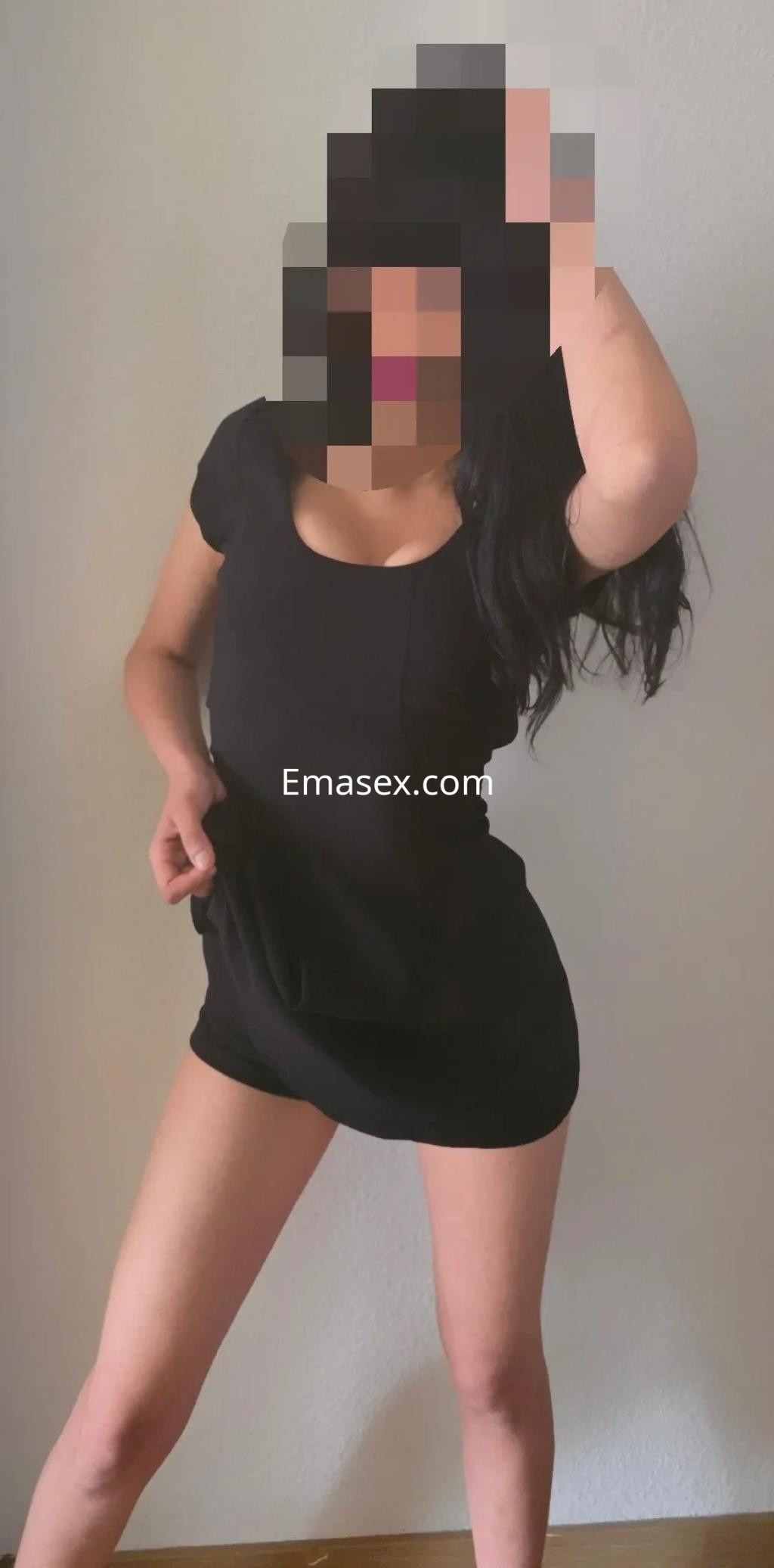 Escort en Oviedo posa con un vestido negro ajustado, mostrando una actitud segura y seductora.