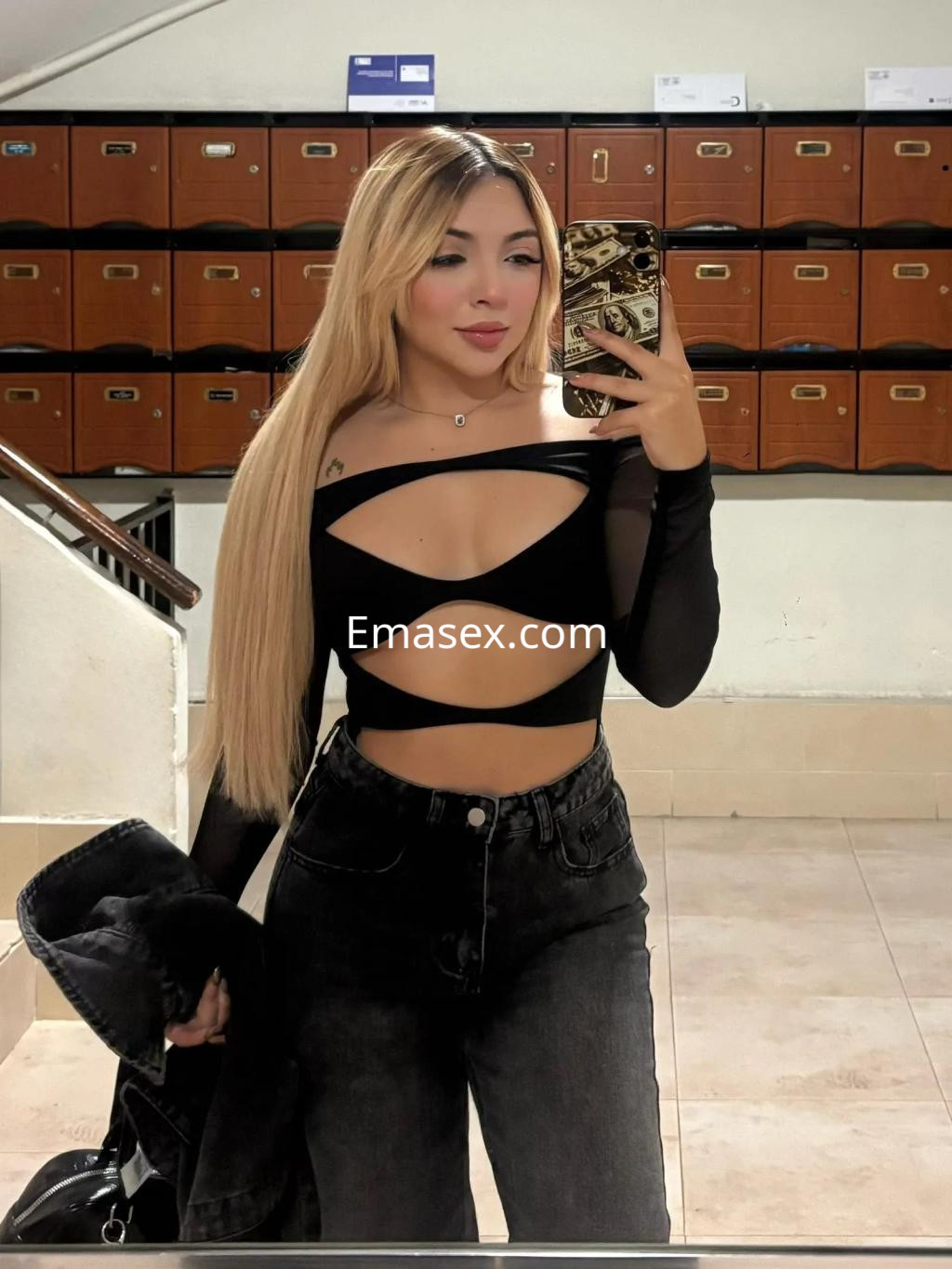 La puta en Valencia luce un top negro de manga larga con cortes, combinado con jeans oscuros y cabello largo.