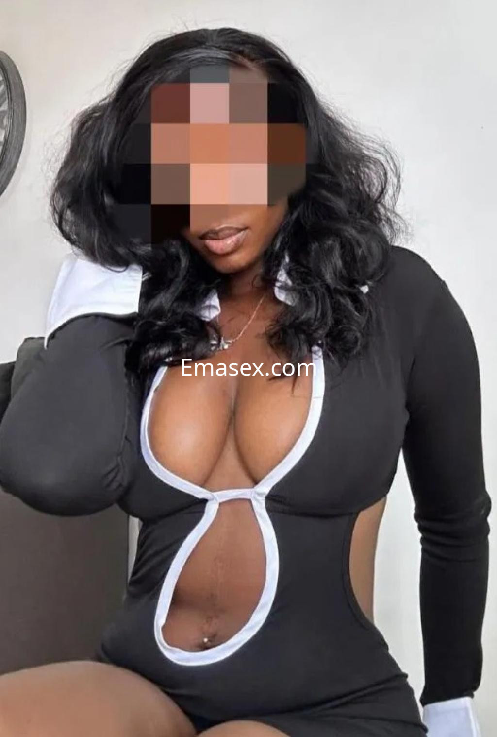 Escort en Logroño viste un vestido negro con detalles en blanco, mostrando una pose seductora y cabello largo.