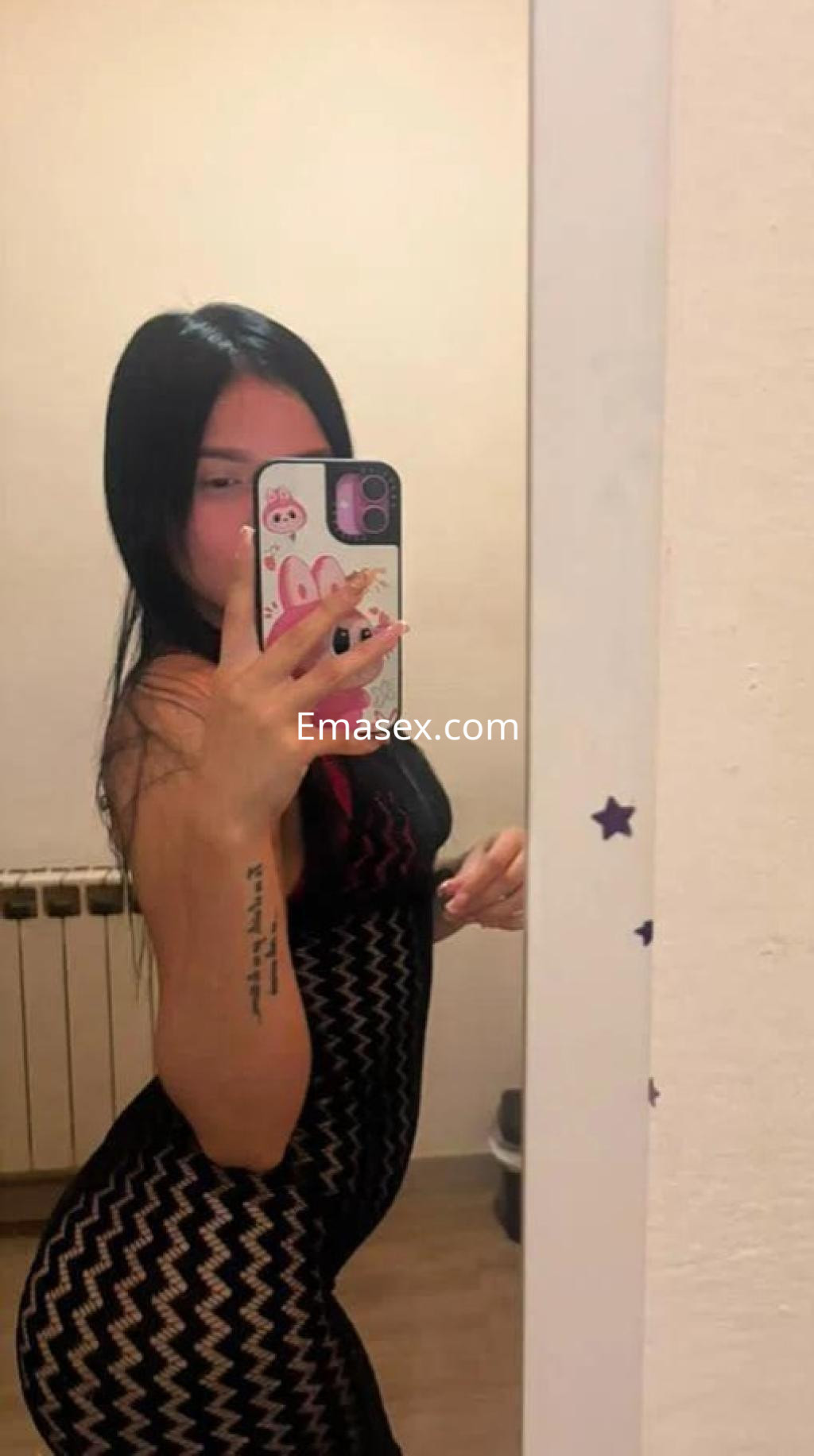 Puta en Las Palmas posando frente al espejo con un vestido negro ajustado y cabello largo y lacio.