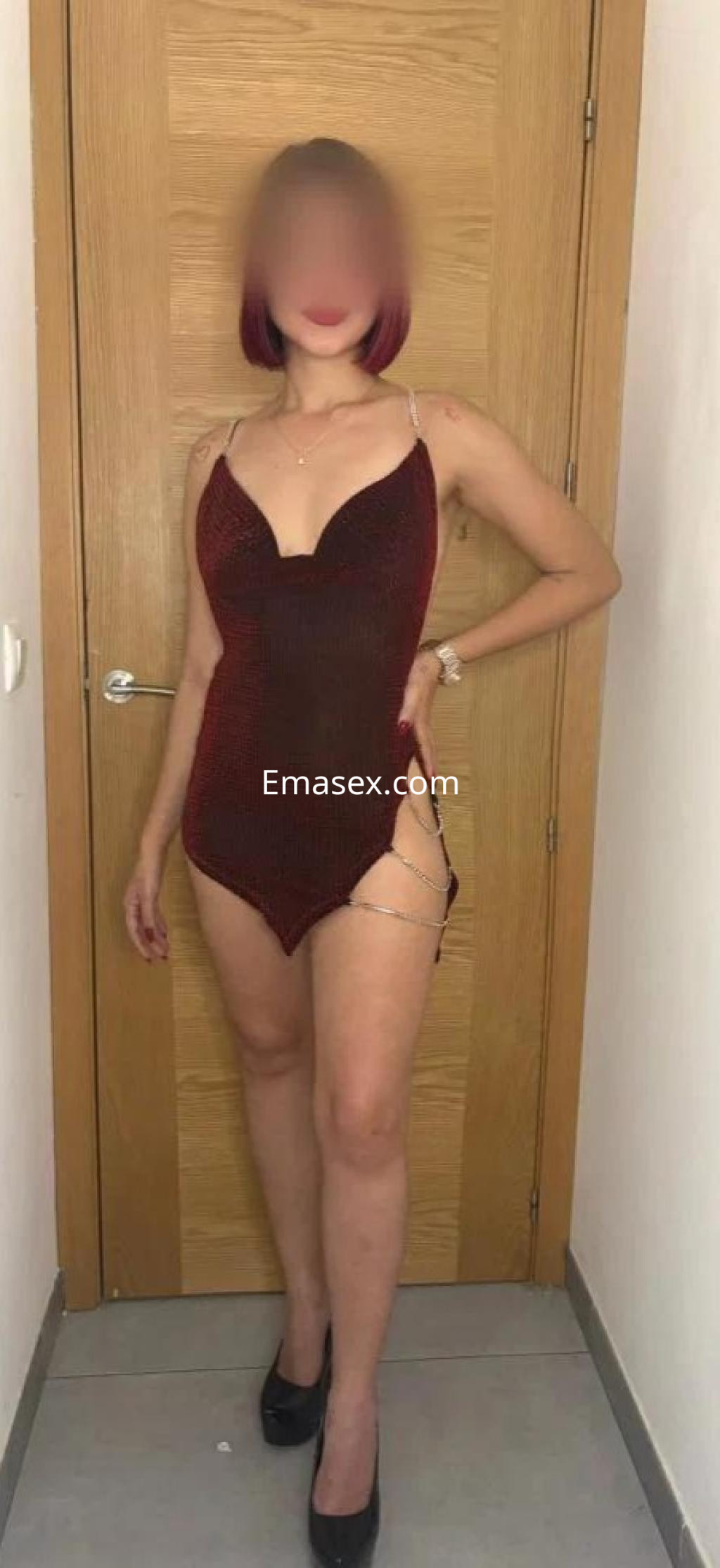 Puta en Córdoba posando con un vestido rojo ajustado y tacones, mostrando una actitud segura frente a la cámara.
