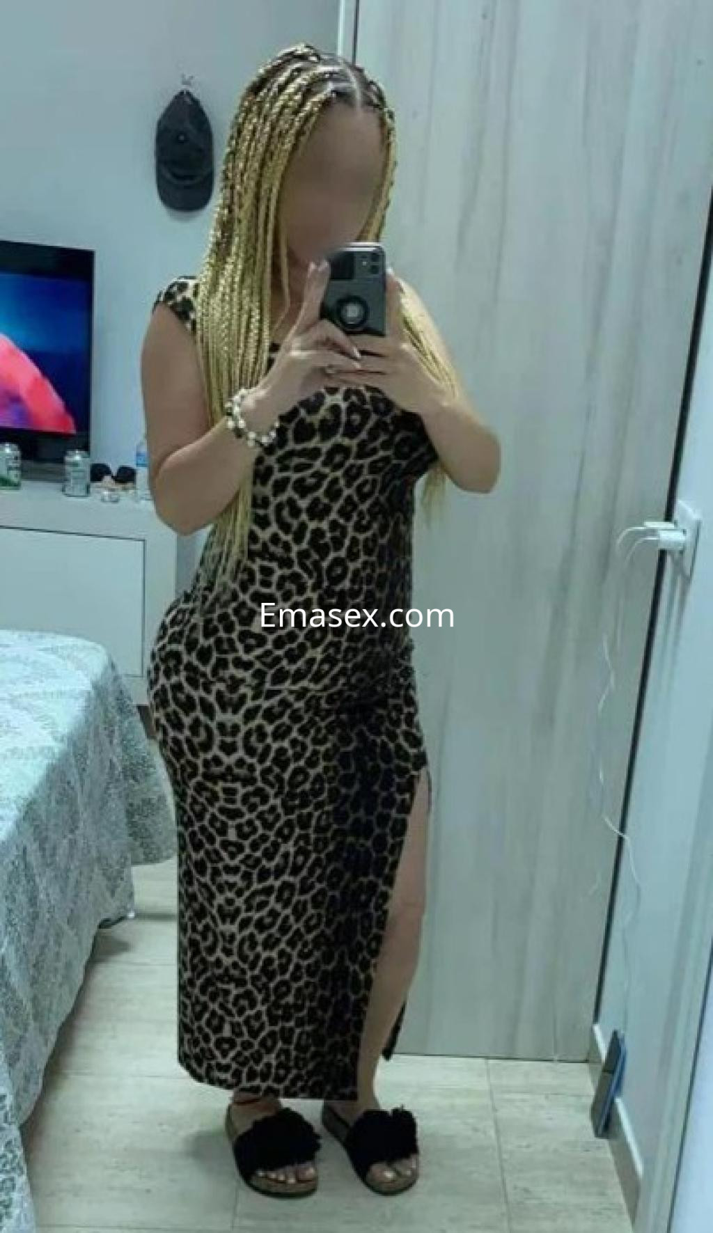Puta con cabello trenzado y vestido de leopardo, posando frente a un espejo en Córdoba.