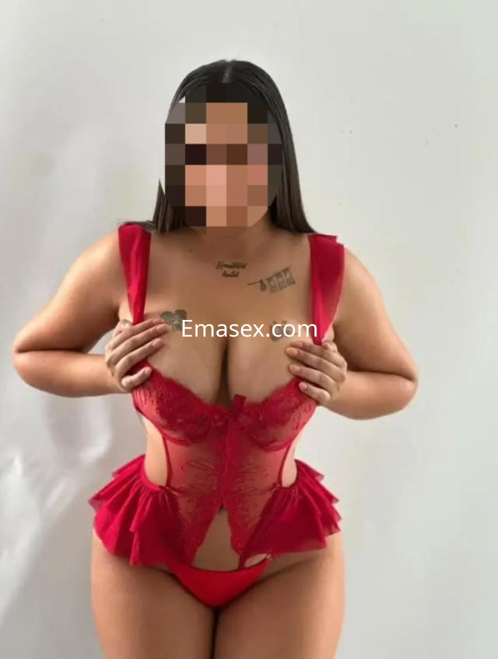 Puta posando con un body rojo ajustado, mostrando una figura curvilínea, en un fondo blanco en Lleida.