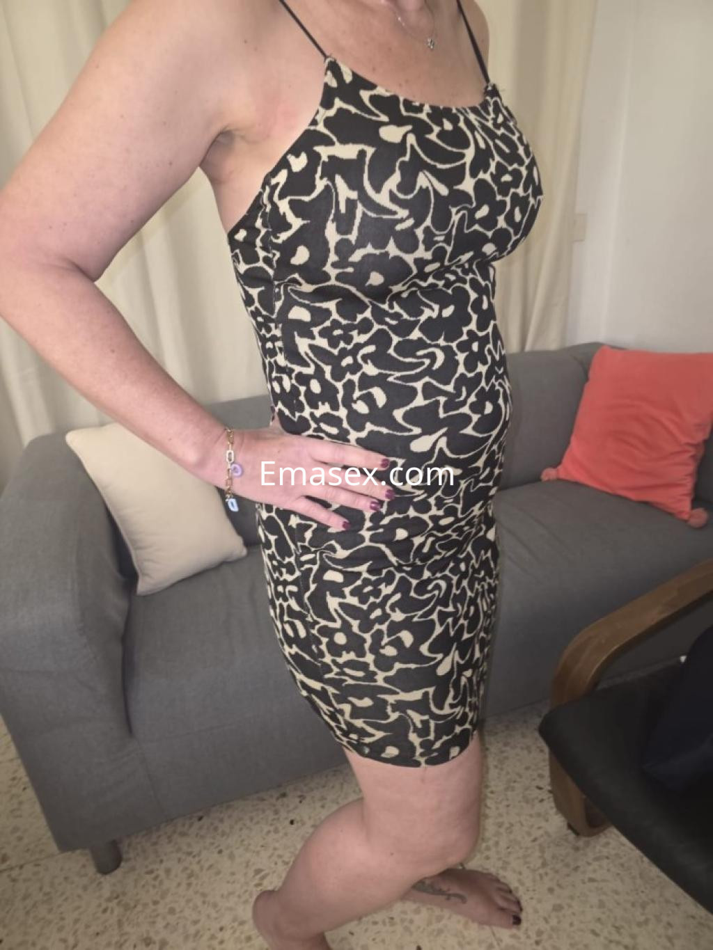 Puta en Tenerife luciendo un vestido ajustado con estampado de leopardo, posando en un salón moderno.
