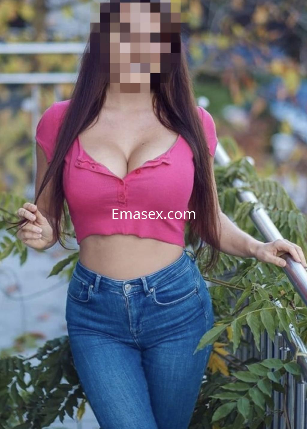 Puta en Donosti, posando con una blusa rosa ajustada y jeans, rodeada de vegetación.