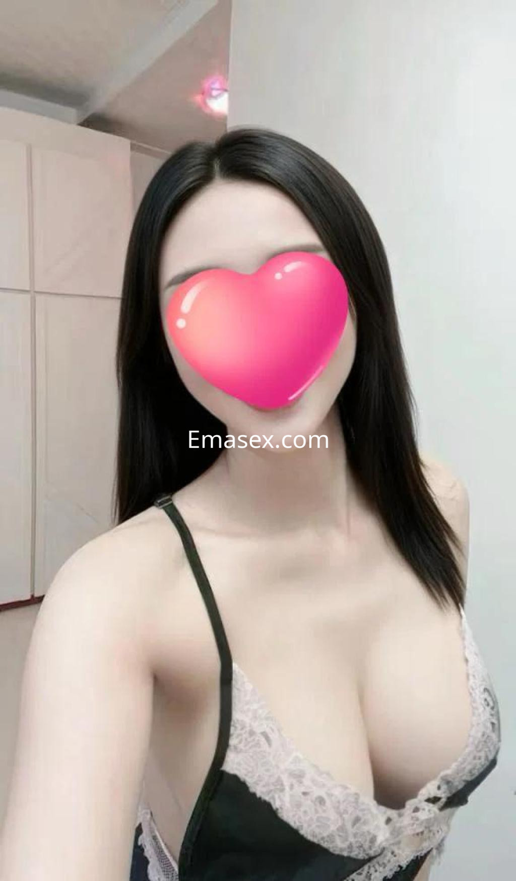 Escort en Málaga con cabello lacio y oscuro, vistiendo un conjunto de lencería en tonos negro y rosa.