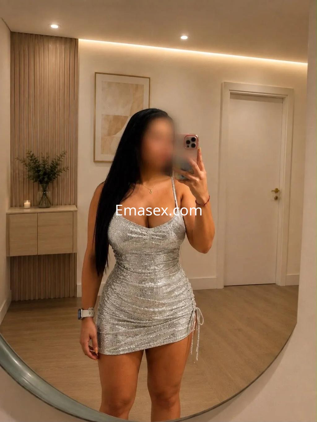 La puta posa en un vestido plateado ajustado en un elegante interior de Valencia, mostrando su cabello largo y lacio.