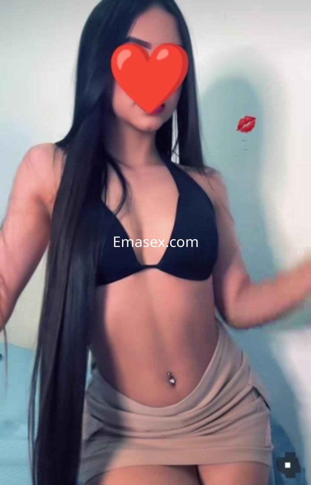 Escort en Ibiza con cabello largo y lacio, vistiendo un top negro y una falda corta beige.