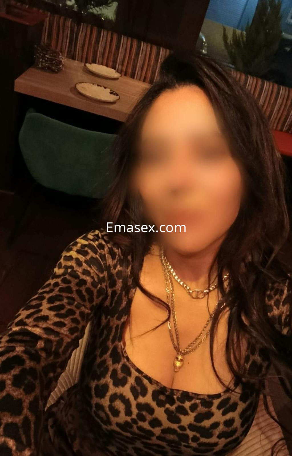 Puta en Girona, con un vestido de leopardo y joyas, posando en un ambiente acogedor y moderno.