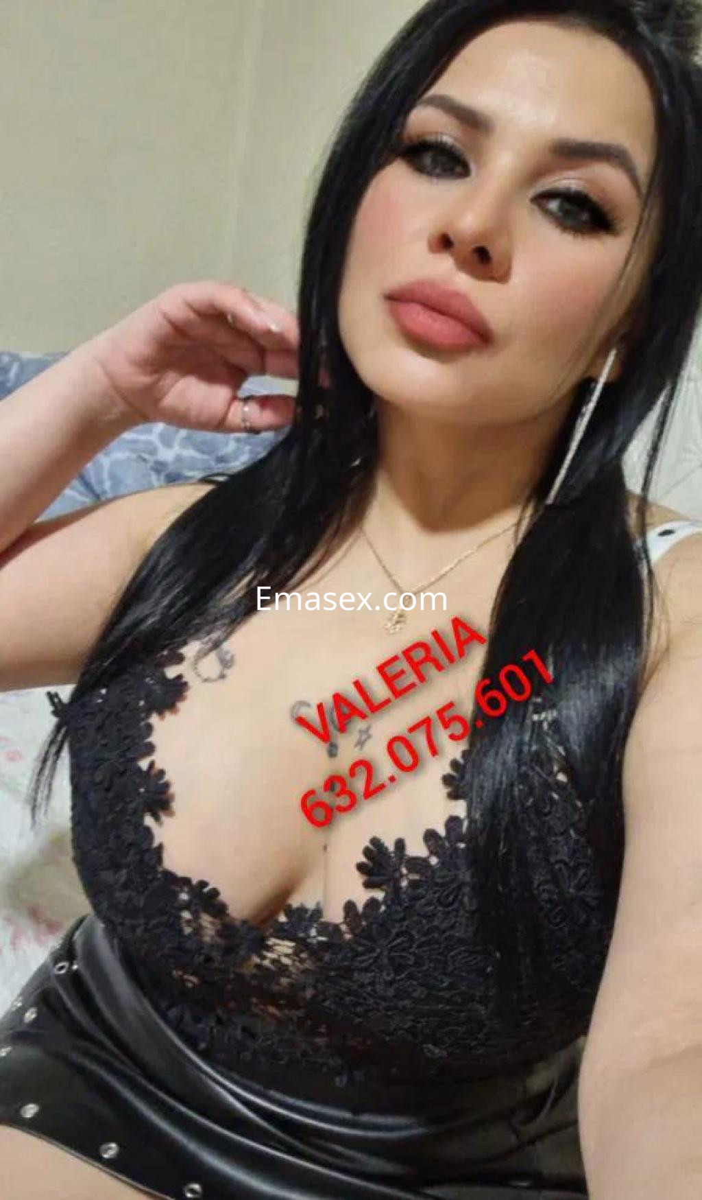 Escort en Lugo posa con blusa negra de encaje y falda de cuero, luciendo un peinado de cabello largo y lacio.