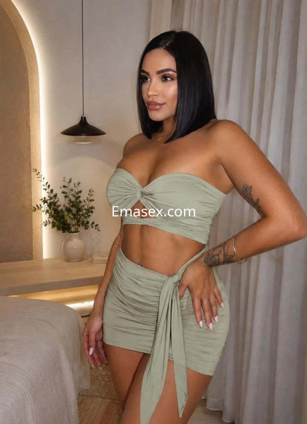 Escort en Málaga, luciendo un conjunto de dos piezas en tono verde claro, con un top ajustado y una falda corta.