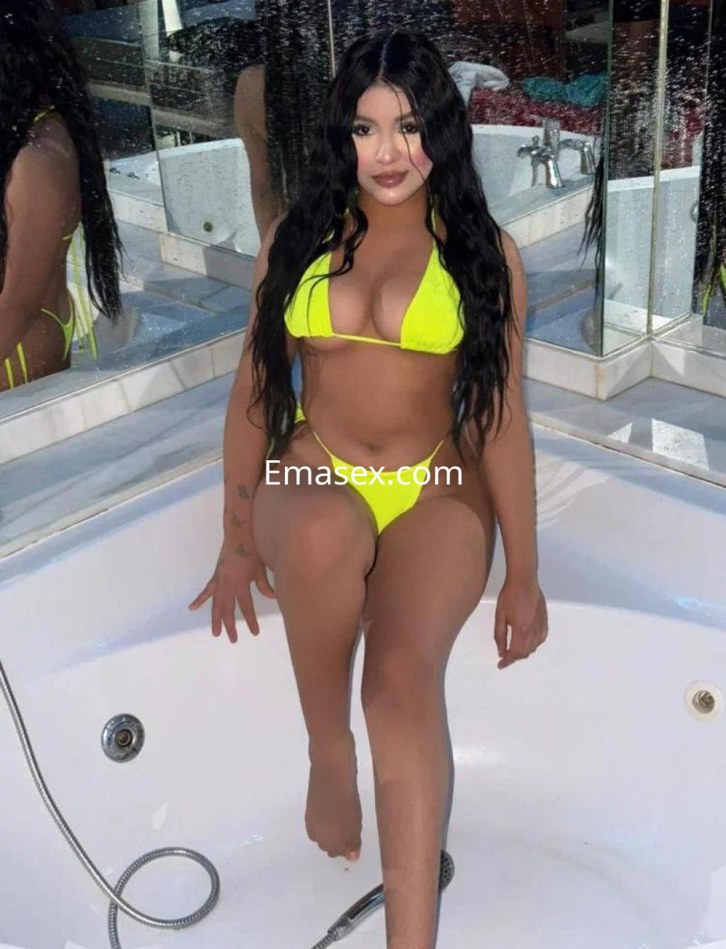 Puta en Toledo luciendo un bikini amarillo brillante mientras se sienta en la bañera, con cabello largo y ondulado.