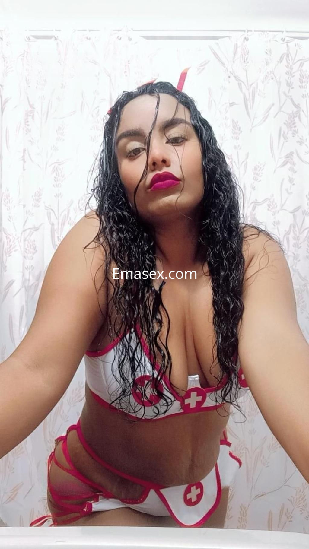 La puta en Pontevedra viste un atrevido uniforme de enfermera con detalles en rojo y blanco, luciendo sensual.
