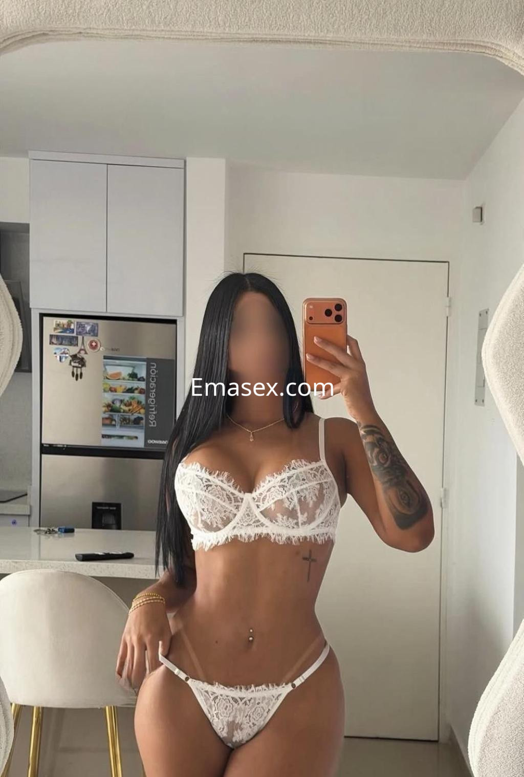 La escort en Sevilla posa frente al espejo con lencería blanca, mostrando su figura esculpida y cabello largo.