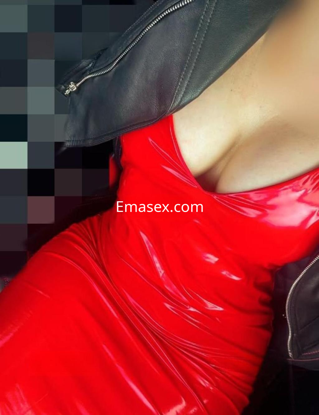 Escort en Sevilla con un vestido rojo ajustado y una chaqueta de cuero, mostrando un estilo atrevido y seductor.