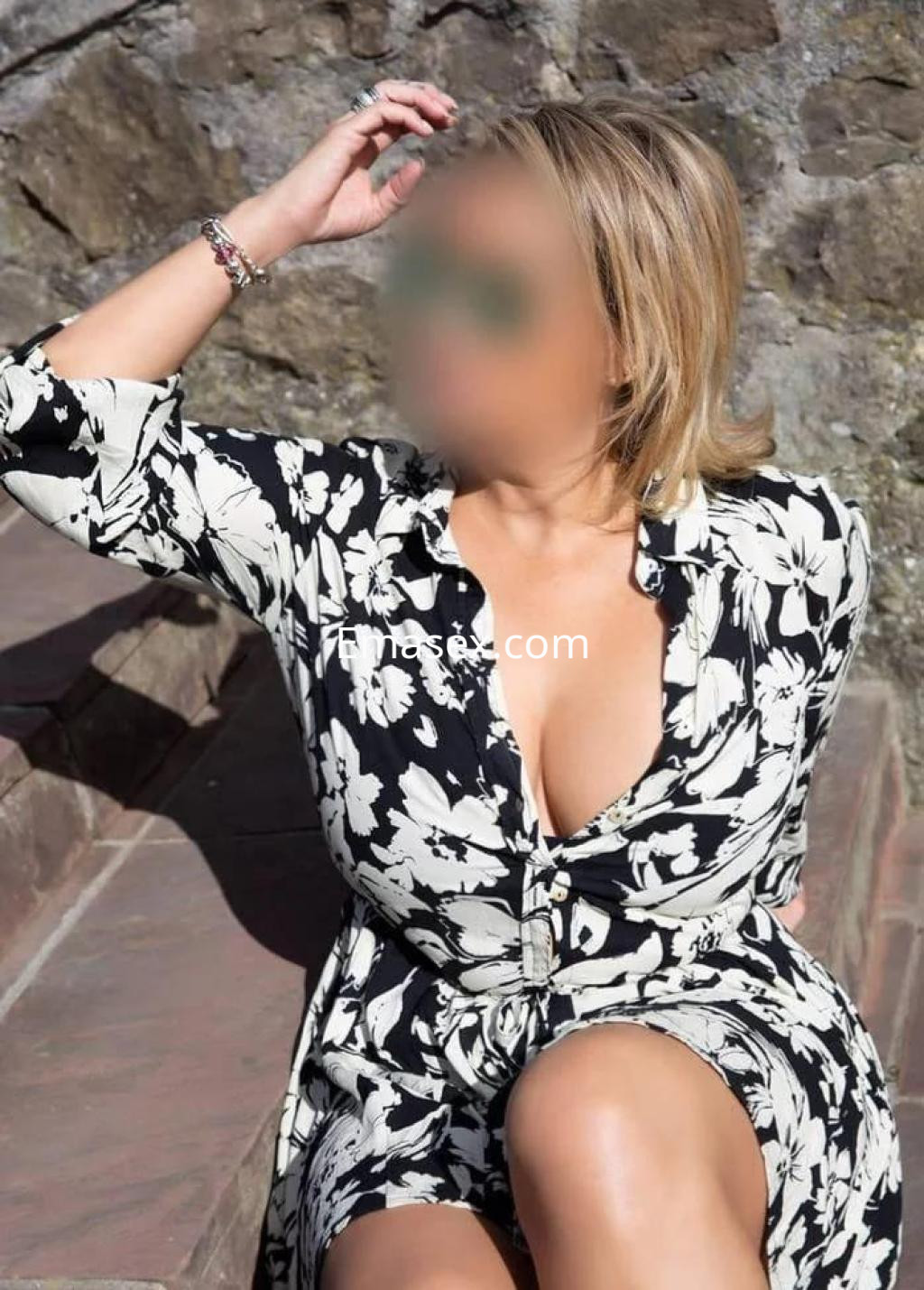 La puta se encuentra en Badajoz, sentada en escaleras, vistiendo un vestido de flores y mostrando una pose relajada.