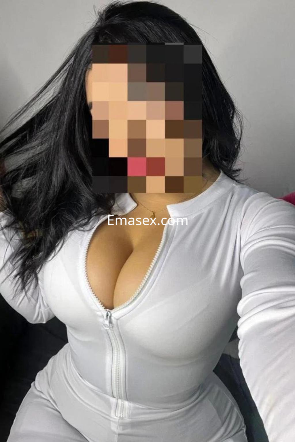 La escort en Coruña luce un ajustado conjunto blanco con cremallera, mostrando su figura y cabello suelto.