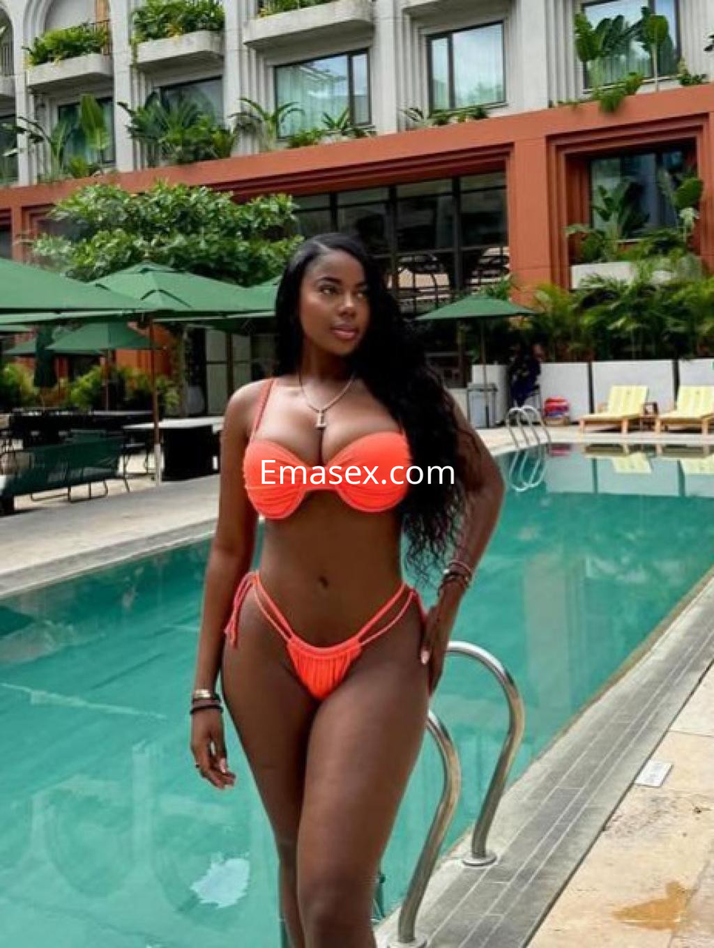 Puta luciendo un bikini naranja mientras se posa con confianza junto a una piscina en Girona.