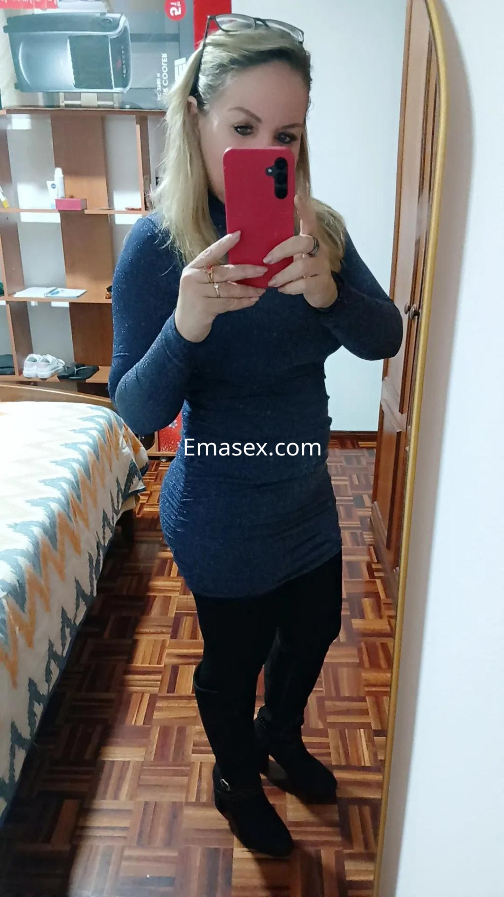 Puta en Vigo con vestido ajustado de color azul oscuro y leggings negros, posando frente al espejo.