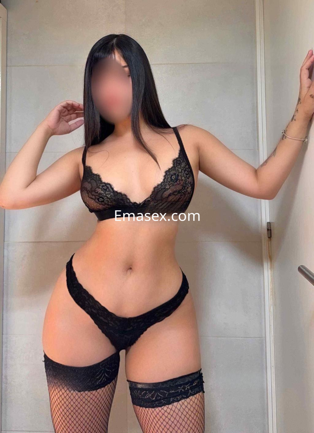 Escort en Barcelona posando con lencería negra, luciendo un peinado lacio y una figura esbelta.
