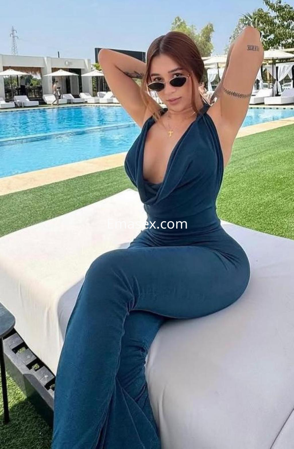 Puta posando en un entorno al aire libre en Palma de Mallorca, luciendo un vestido azul y gafas de sol.