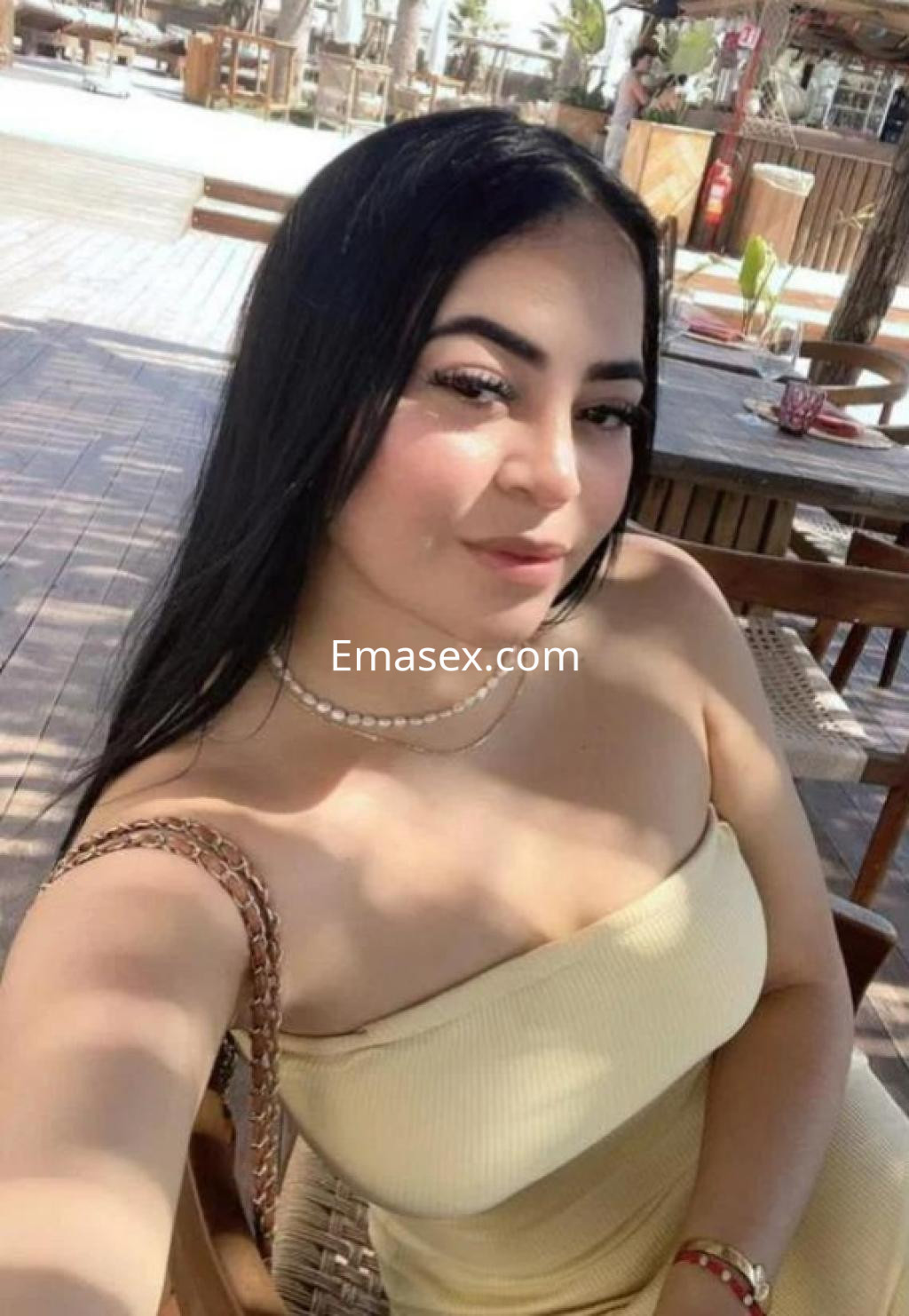 Puta en Madrid toma un selfie luciendo un vestido amarillo sin mangas y con su cabello largo y lacio.