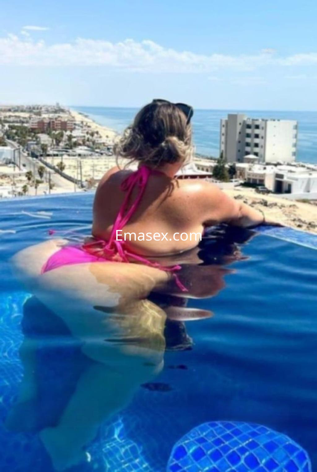 La puta posa desde una piscina de borde infinito en Granada, luciendo un bikini rosa y disfrutando del paisaje.