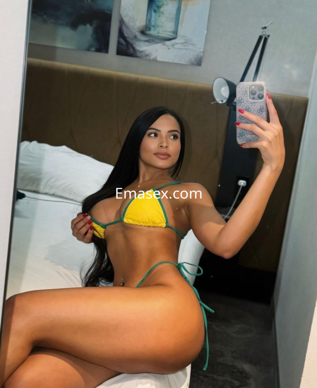 Escort en Málaga se fotografía en un entorno interior, luciendo un bikini amarillo y verde que resalta su figura.