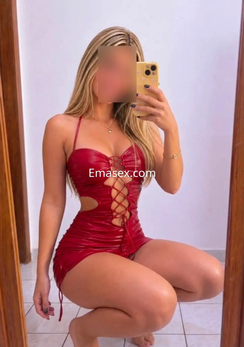 Puta en Granada posa en un vestido rojo ajustado con detalles de encaje, mostrando sus piernas y un entorno interior.