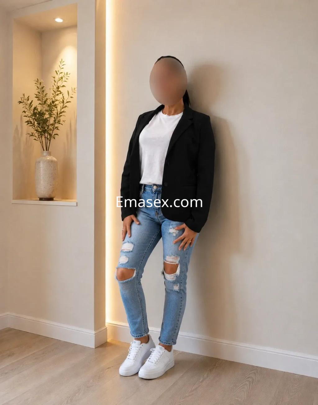 La puta viste una camiseta blanca y un blazer negro, con jeans rasgados y zapatillas blancas en Valencia.