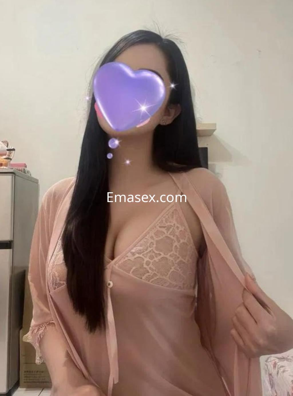 Escort en Barcelona lleva un kimono rosa claro sobre un conjunto de lencería, mostrando su cabello largo y lacio.