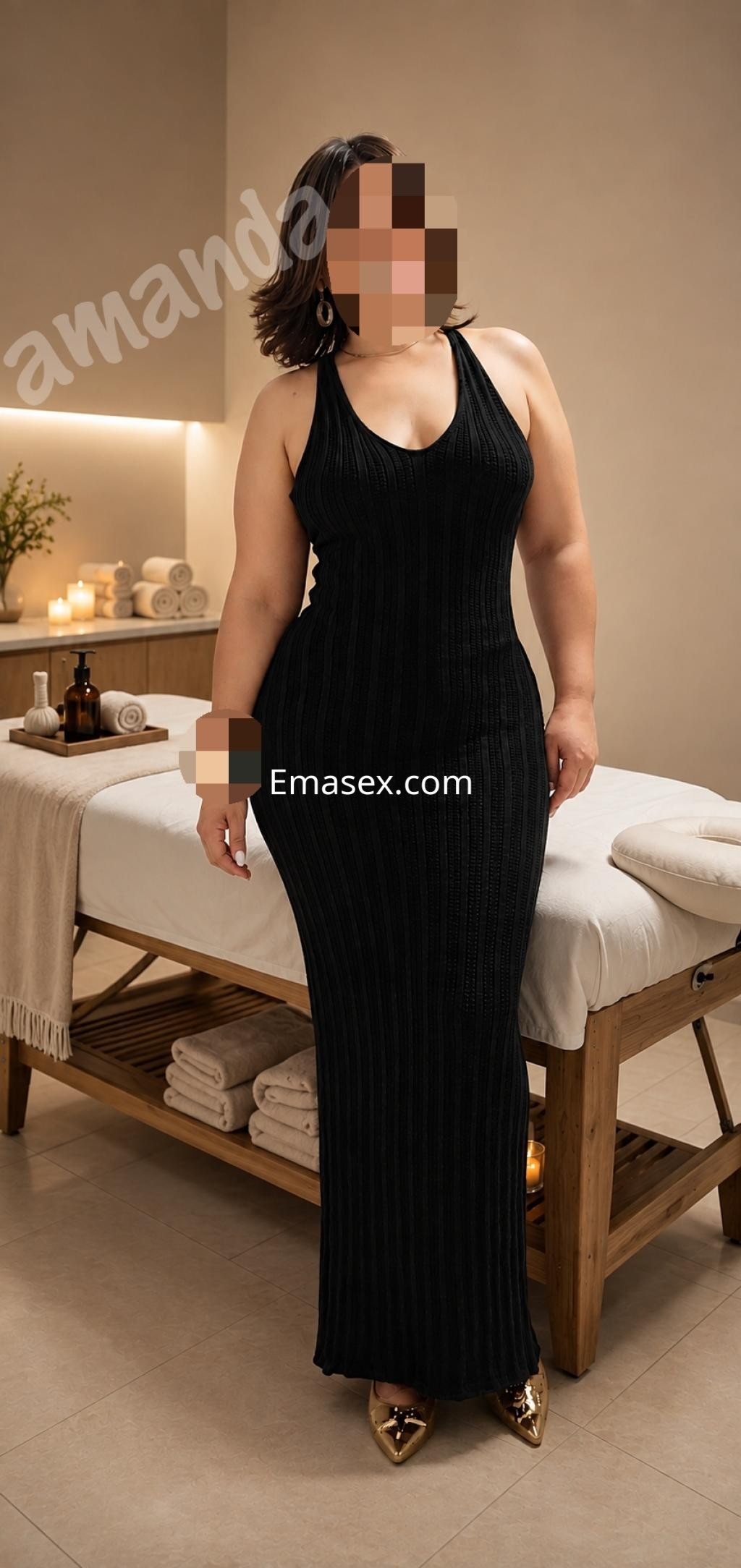 Escort en Pamplona, vistiendo un vestido negro ajustado, de pie en un ambiente relajante con toallas.