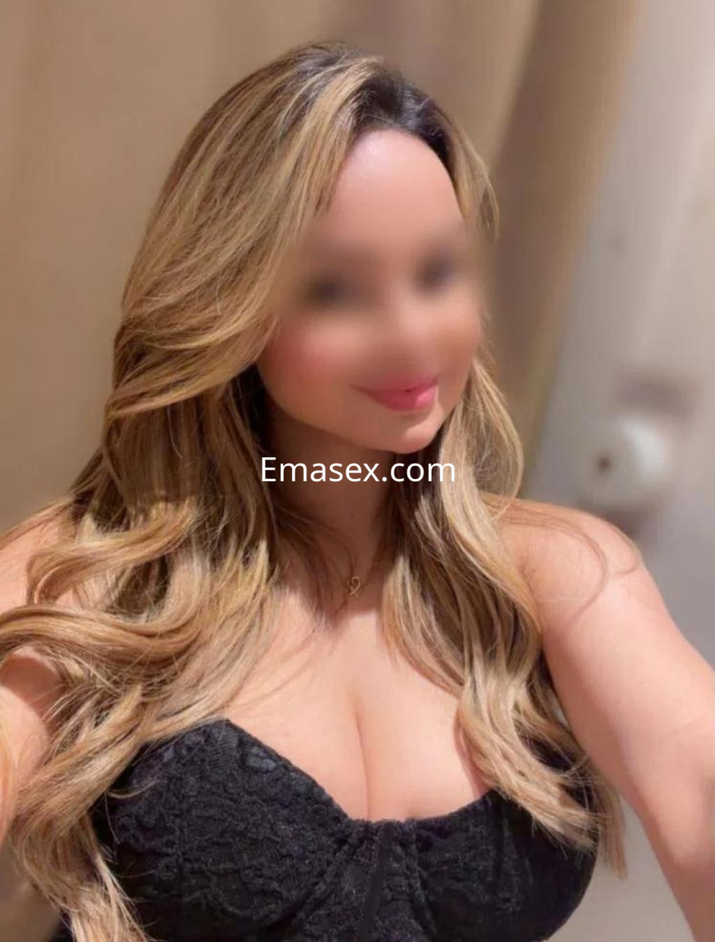 Puta en Barcelona con cabello largo y rubio, luciendo un vestido negro ajustado que resalta su figura.